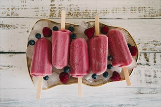 Berry ice pops with berries on plate