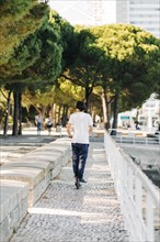 Young man using electric scooter on pavement