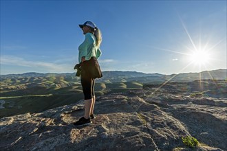 Mature woman standing on rocks at sunset in Boise