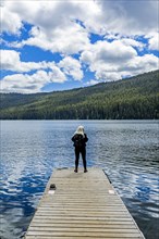 Woman standing on jetty on lake in Stanley