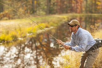 Man fly-fishing in river during autumn in Giles County