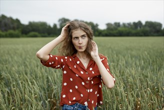 Woman making face in wheat field