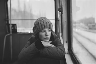 Teenage girl wearing woolly hat on train