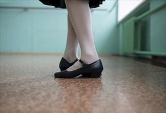 Feet of ballet dancer wearing black shoes