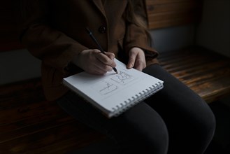 Woman drawing in note pad on train