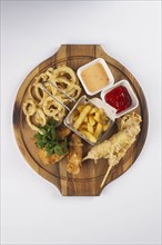 Deep fried snacks and sauce on cutting board