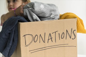 Girl putting clothing into donations box