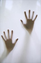 Woman's hands touching frosted glass