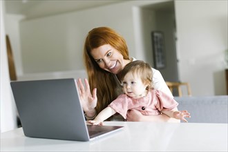 Mother and daughter using laptop to video chat