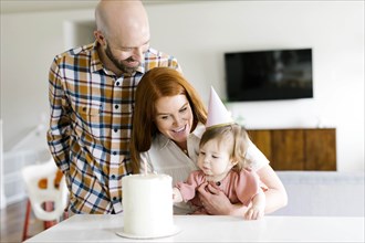 Parents and daughter with birthday cake