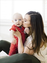 Woman kissing her baby boy's cheek