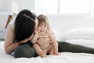 Woman kissing her daughter's cheek