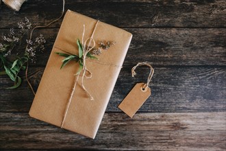 Present wrapped in brown paper and string with label and flowers