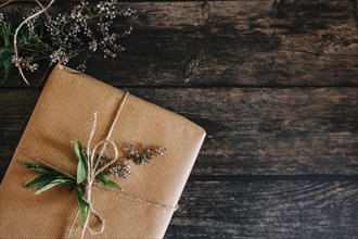 Present wrapped in brown paper with string and flowers