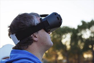 Mid adult man wearing virtual reality simulator outdoors