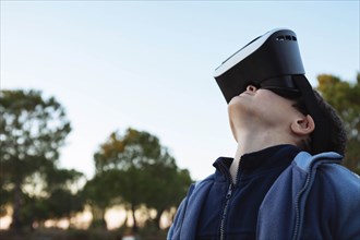 Boy wearing virtual reality simulator outdoors