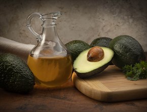 Avocados with pitcher of oil
