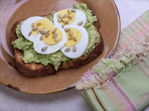 Avocado and egg on toast with sunflower seeds