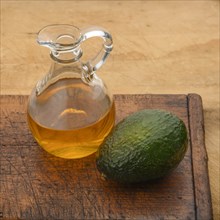 Avocado with pitcher of oil