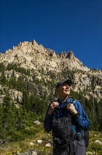 Smiling man hiking on Sawtooth Mountains in Stanley, Idaho, USA