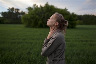 Young woman with her eyes closed in field