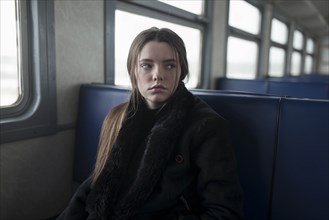 Young woman wearing black fur coat on train