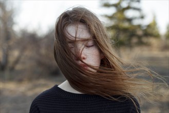 Portrait of windswept teenage girl with her eyes closed