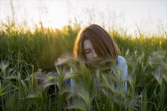 Young woman lying in wheat field