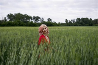 Woman with pink hair in wheat field