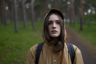 Portrait of young woman wearing brown raincoat