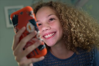 Girl smiling using smartphone
