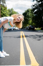 Girl leaning over on road