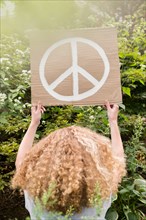 Girl holding sign with peace symbol