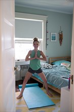 Girl doing yoga in bedroom