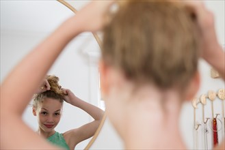 Girl doing hair in mirror
