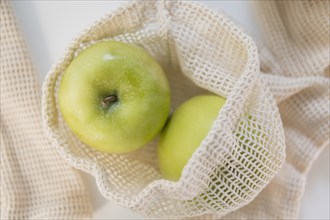 Green apples in reusable bag