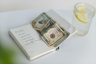 Budget list in notebook with money