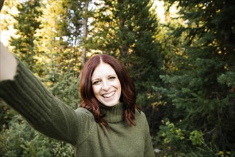 Woman taking selfie in forest