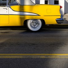 Yellow old fashioned car on road
