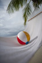 Beach ball on hammock under palm tree in Ari Atoll, Maldives, South Asia