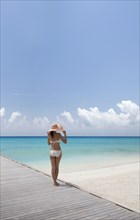 Woman wearing bikini by beach in South Male Atoll, Maldives, South Asia