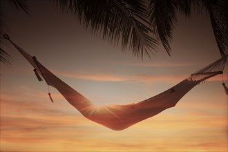 Woman inside hammock at sunset at Miami Beach in Miami, Florida, USA