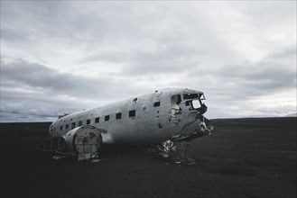 Abandoned airplane in black sand desert