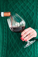 Woman wearing green pouring glass of wine