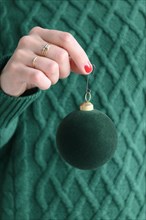 Woman wearing green holding green bauble