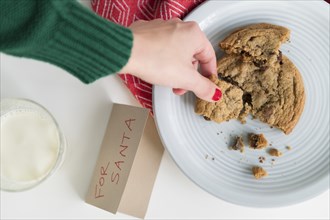 Woman picking up cookie by card for Santa
