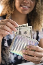 Smiling woman holding wallet with money