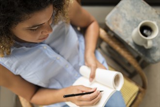 Woman sitting in chair writing in notebook
