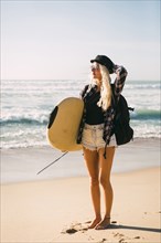 Woman holding surfboard on beach