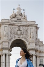 Smiling woman by Rua Augusta Arch in Lisbon, Portugal